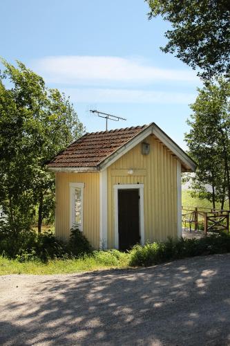 un pequeño edificio amarillo con una puerta en un campo en Putka , Jailhouse, en Salo