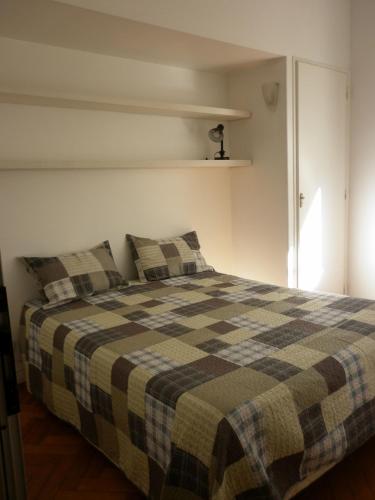 a bedroom with a bed with a checkered blanket at Excelente departamento en Retiro in Buenos Aires