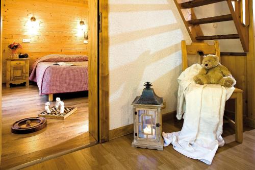 a teddy bear sitting on a chair in a bedroom at Hôtel Belalp in Châtel