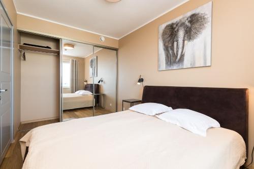 1 dormitorio con 1 cama blanca grande y espejo en Viru Väljak Lux Apartment, en Tallin