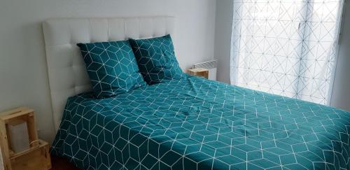 - un lit avec une couette bleue dans une chambre dans l'établissement Chez Damien, à Colmar