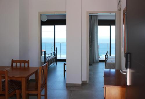 - une salle à manger avec une table et une vue sur l'océan dans l'établissement panorama studios, à Afytos