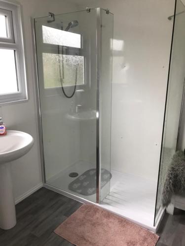 a shower with a glass door in a bathroom at Nicolas Devon air bed and breakfast in Ilfracombe
