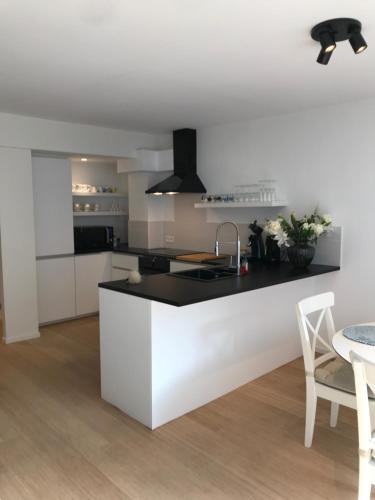 a kitchen with a white and black counter and a table at Ocean Breeze in Ostend