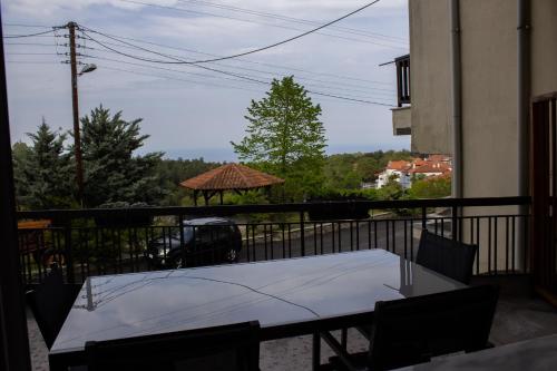 una mesa y sillas en un balcón con cenador en Veranda Guest House, en Litóchoron