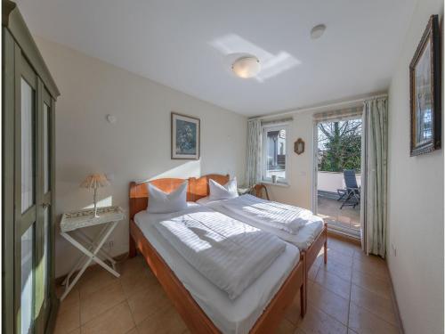 1 dormitorio con cama, mesa y ventana en Altstadt - Apartments, en Waren