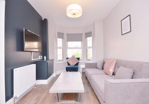 a living room with a couch and a table at Modern Queens Quarter Townhouse 1 in Belfast
