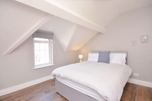 a bedroom with a white bed and a window at Queens Quarter Townhouse 1 in Belfast