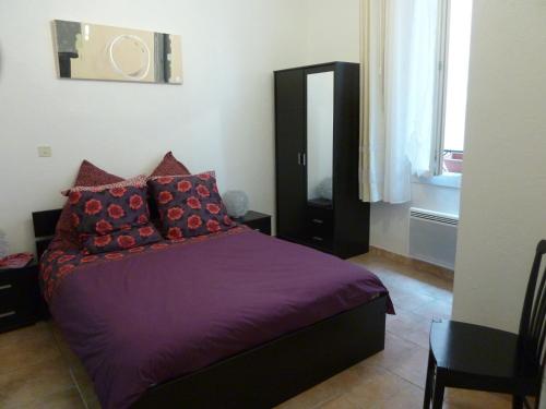 a bedroom with a purple bed with red pillows at 6 rue de la tourraque in Antibes