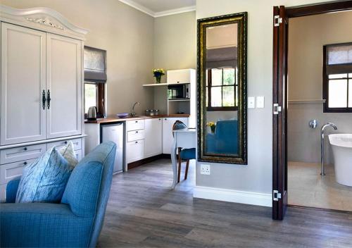 a living room with a blue couch and a mirror at Huguenot House in Franschhoek