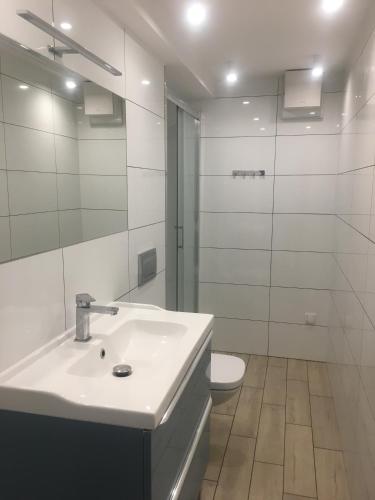 a white bathroom with a sink and a toilet at Dwa osobne pokoje z kuchnią i łazienką na wyłączność- niedaleko plaży in Gdynia