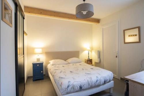 a small bedroom with a bed and two lamps at Studio Nathalie et Sebastien in La Brede