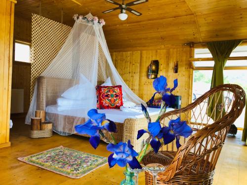 sypialnia z łóżkiem z niebieskimi kwiatami w pokoju w obiekcie Dream Tricule w mieście Sviniţa