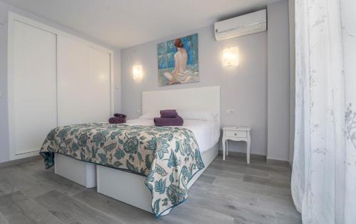 1 dormitorio con 1 cama y una pintura en la pared en Precioso apartamento al lado de la playa, en Benalmádena