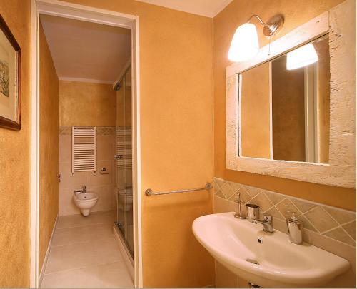 ein Badezimmer mit einem Waschbecken, einem WC und einem Spiegel in der Unterkunft Casacenti B&B in Siena