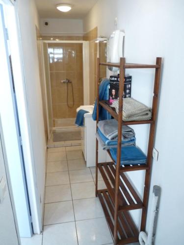 baño con ducha y estante de madera en appartement de la callade en Peyriac-de-Mer