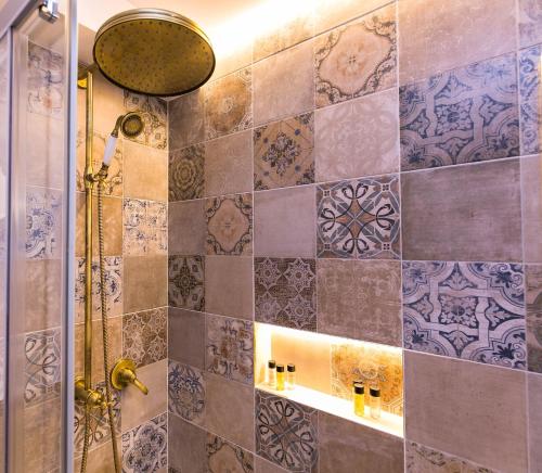 a bathroom with a shower with a tiled wall at The Old Town Square & Parizska Apartments in Prague