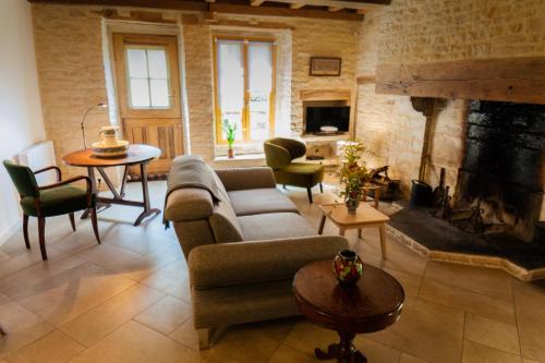 un salon avec un canapé et une cheminée dans l'établissement Relais de la Fontaine - Maison de charme, à Cunfin