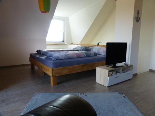 um quarto com uma cama e uma televisão numa mesa em Ferienwohnung Ochtmissen em Lüneburg