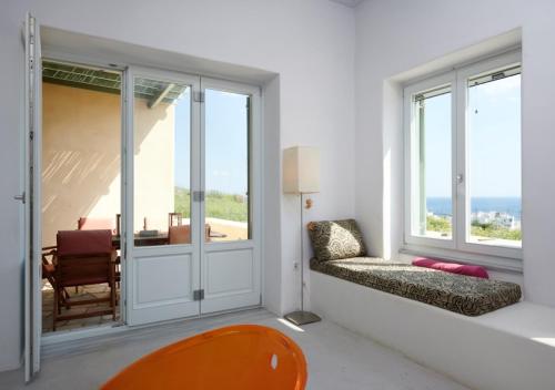 sala de estar con ventanas grandes y sofá en Villa Rosa-Maria en Tinos Town
