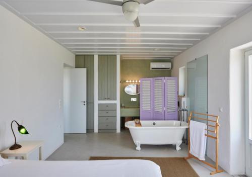 W łazience znajduje się biała wanna oraz łóżko i wanna. w obiekcie Villa Rosa-Maria w mieście Tinos