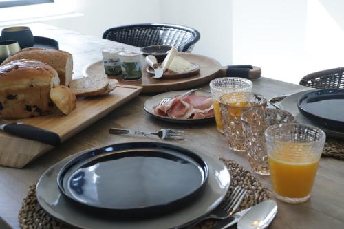 una mesa con un plato de pan y zumo de naranja en ma-tinée, en Beauvechain