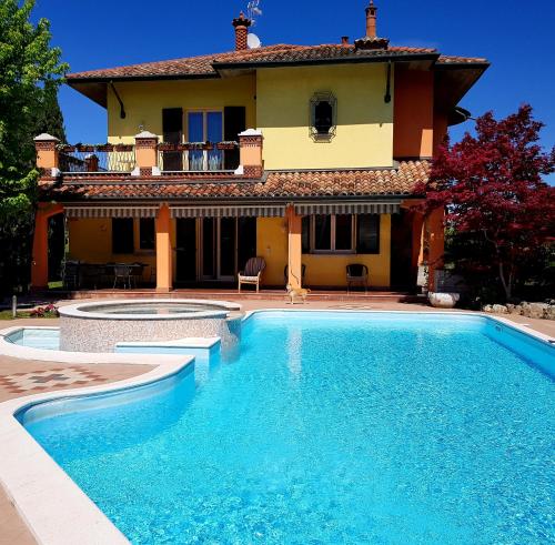 a swimming pool in front of a house at B&B Villa Giulia in Desenzano del Garda