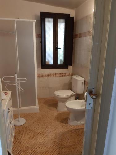 a bathroom with a toilet and a window at VILLETTA ROSA IV strada Fegotto in Floridia