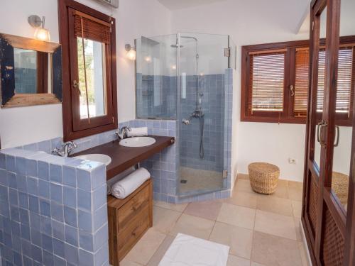 a blue tiled bathroom with a sink and a shower at Ses Vistes in Nuestra Señora de Jesus