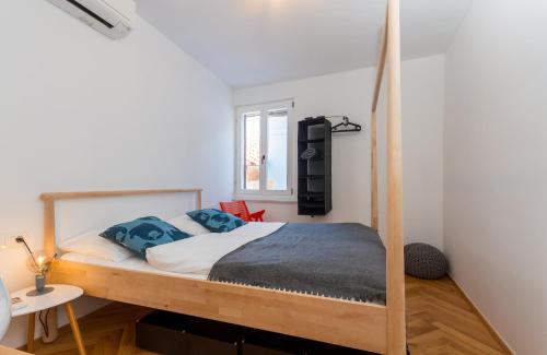 1 dormitorio con litera de madera y almohadas azules en Little Tower With Terrace by Locap Group en Piran