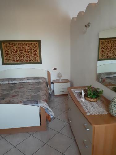 a bedroom with two beds and a dresser and a mirror at VILLETTA ROSA IV strada Fegotto in Floridia