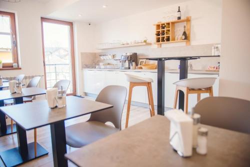 a restaurant with tables and chairs and a kitchen at Penzion Albrechtt in Kežmarok