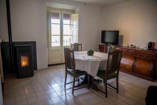 a living room with a table and a television and a fireplace at Ca l'Anyep-L'Ermita in El Vilosell