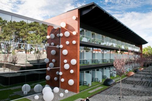 a building with white spheres on the side of it at Evidencia Belverde Hotel in Amora