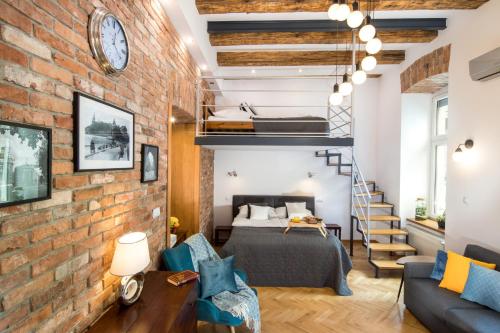 a loft with a bed and a brick wall at Cracowapart Loft Gertruda in Kraków