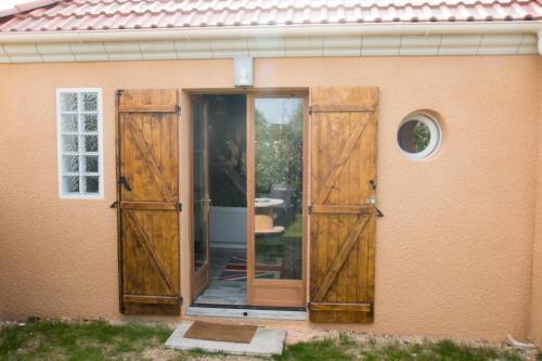 une porte ouverte d'une maison avec des portes en bois dans l'établissement Studio London & Studio Chalet, à Pannes