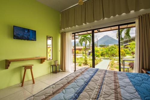 een slaapkamer met een bed en een glazen schuifdeur bij Hotel Secreto La Fortuna in Fortuna