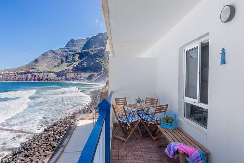 a balcony with a table and chairs and the beach at Hola ola Bajamar in Bajamar