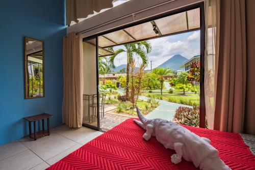 a person laying on a bed in front of a window at Hotel Secreto La Fortuna in Fortuna