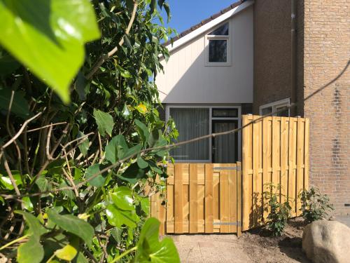 a wooden fence in front of a house at Logies het Noordwestertje in Den Burg