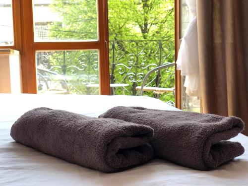 a towel on a bed in front of a window at ROMANTIC Apartments - оn Valova street in Lviv