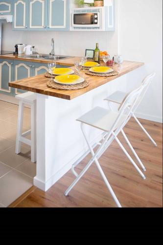 a kitchen with a white island with a table and chairs at Hola ola Bajamar in Bajamar