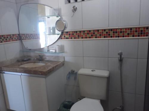 a bathroom with a sink and a toilet and a mirror at Casa Verde in Porto De Galinhas