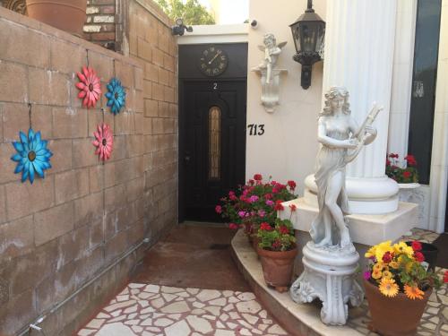 una estatua parada frente a una puerta con flores en Entire Second Flr - Santa Monica Luxury Roman Villa en Los Ángeles