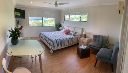 een slaapkamer met een bed, een tafel en een stoel bij Island Views in Airlie Beach