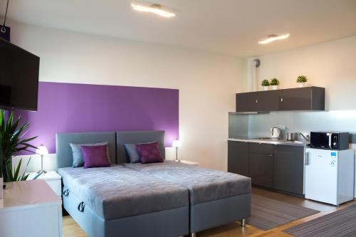 1 dormitorio con cama y pared púrpura en Prague apartment in residential tower · parking en Praga