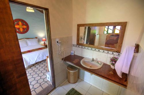 a bathroom with a sink and a bed and a mirror at Pousada e Hostel Pé no Mato in Vale do Capao