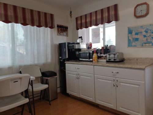 a kitchen with white cabinets and a counter with a microwave at Deluxe Inn in Seligman