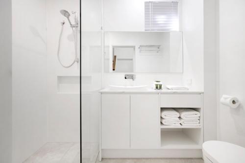 bagno bianco con lavandino e doccia di 1-22 Stevens Street, Sunshine Beach a Noosa Heads