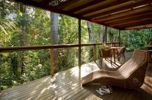 a porch with a table and chairs on a deck at Sharlynn by the River in Malanda